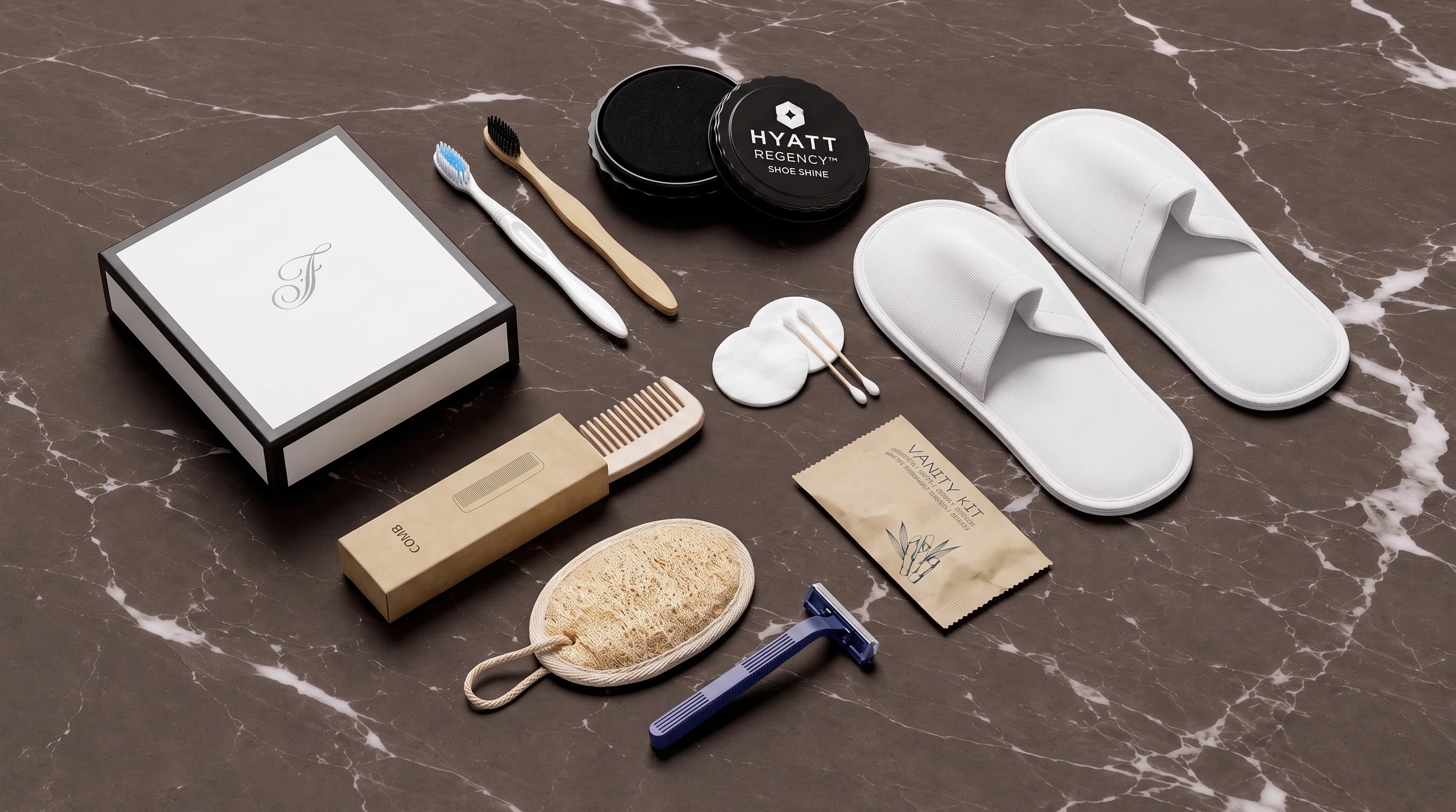 A hotel amenity set — slippers, bamboo and classic toothbrushes, comb, loofah, razor, shoe shine and vanity kit — arranged on dark marble